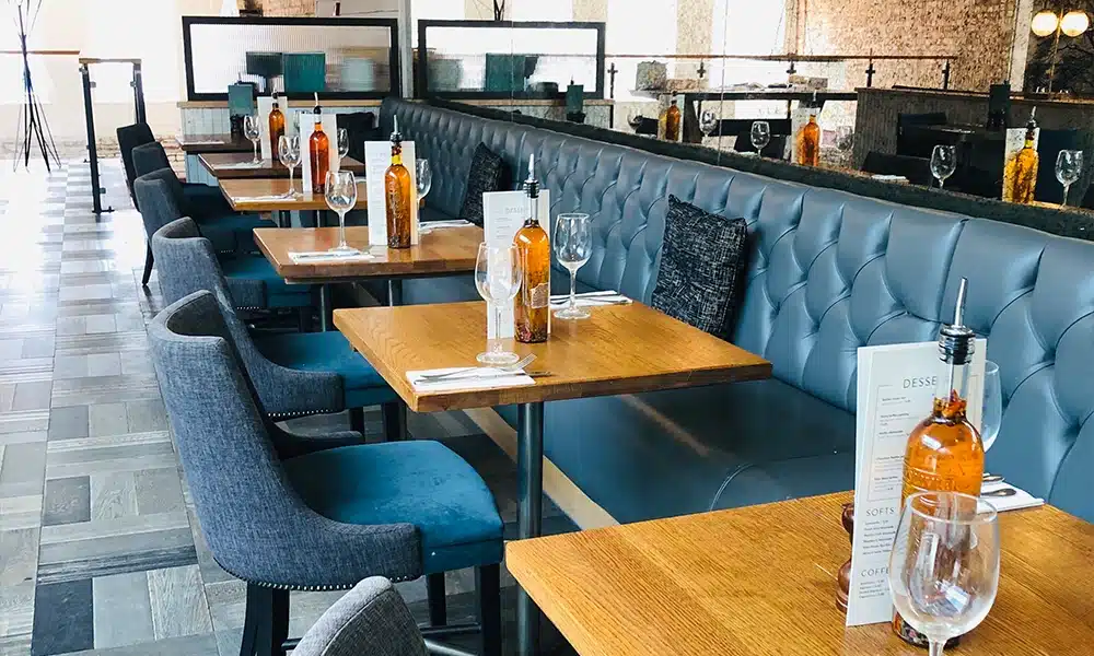 Long run of blue button back banquette seating along a restaurant wall