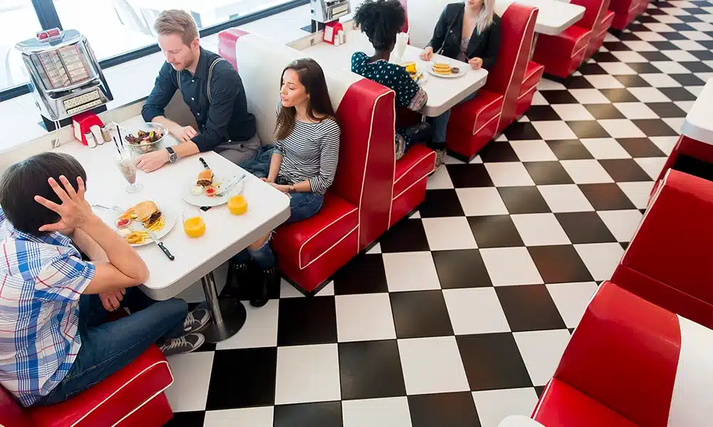 Group of people sitting on retro booth seating in a classic American-style diner