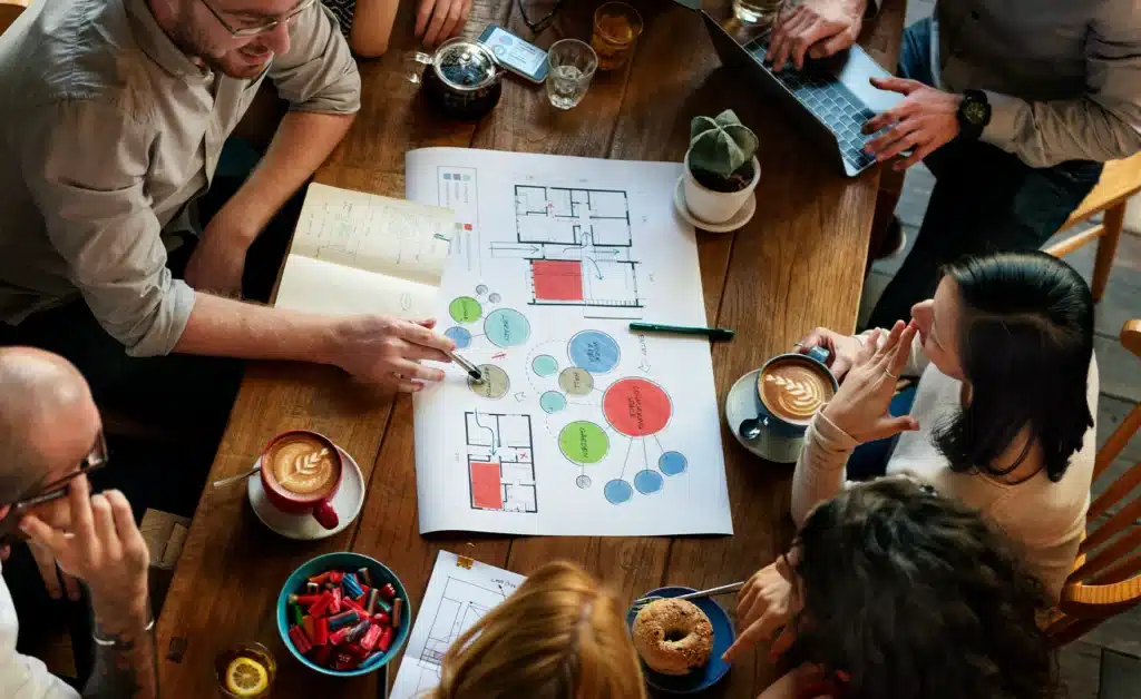 Group around a table having a discussion over a floor plan in a restaurant